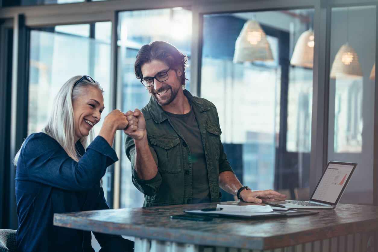 Exper-IS, collègues de travail faisant un fist bump au bureau