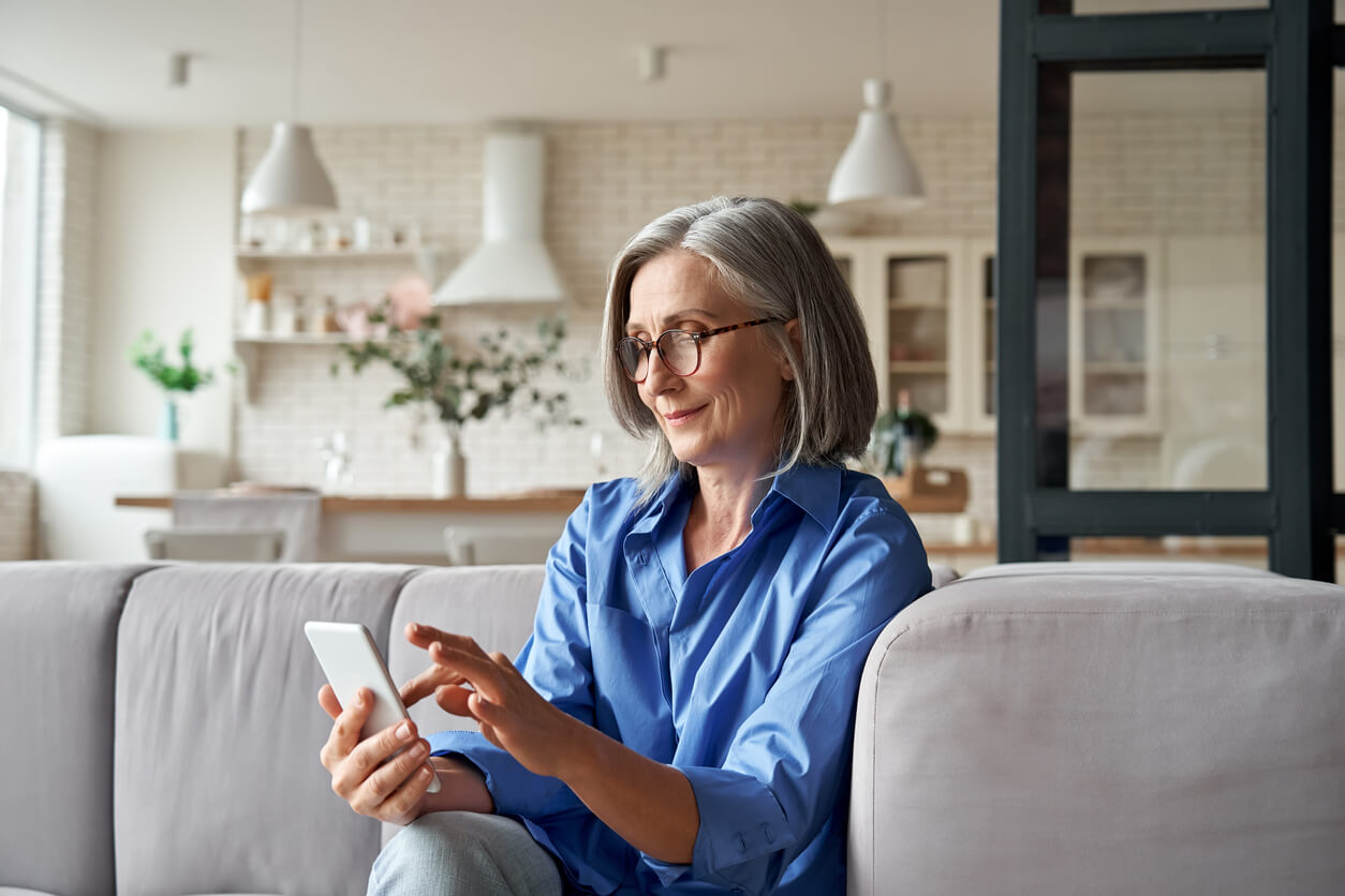 Exper-IS, femme assise sur un canapé utilisant une tablette tactile